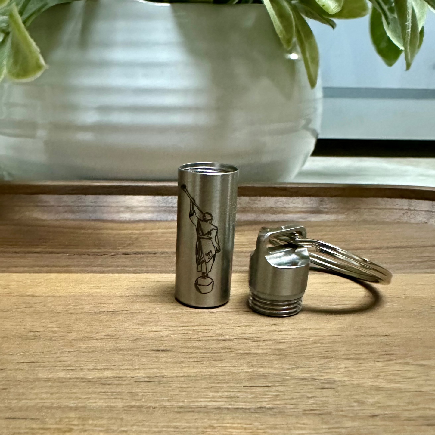 Small consecrated oil vial made of stainless steel with a secure screw cap unscrewed, featuring an elegant engraving of angle Moroni, ideal for Latter-day Saint priesthood blessings