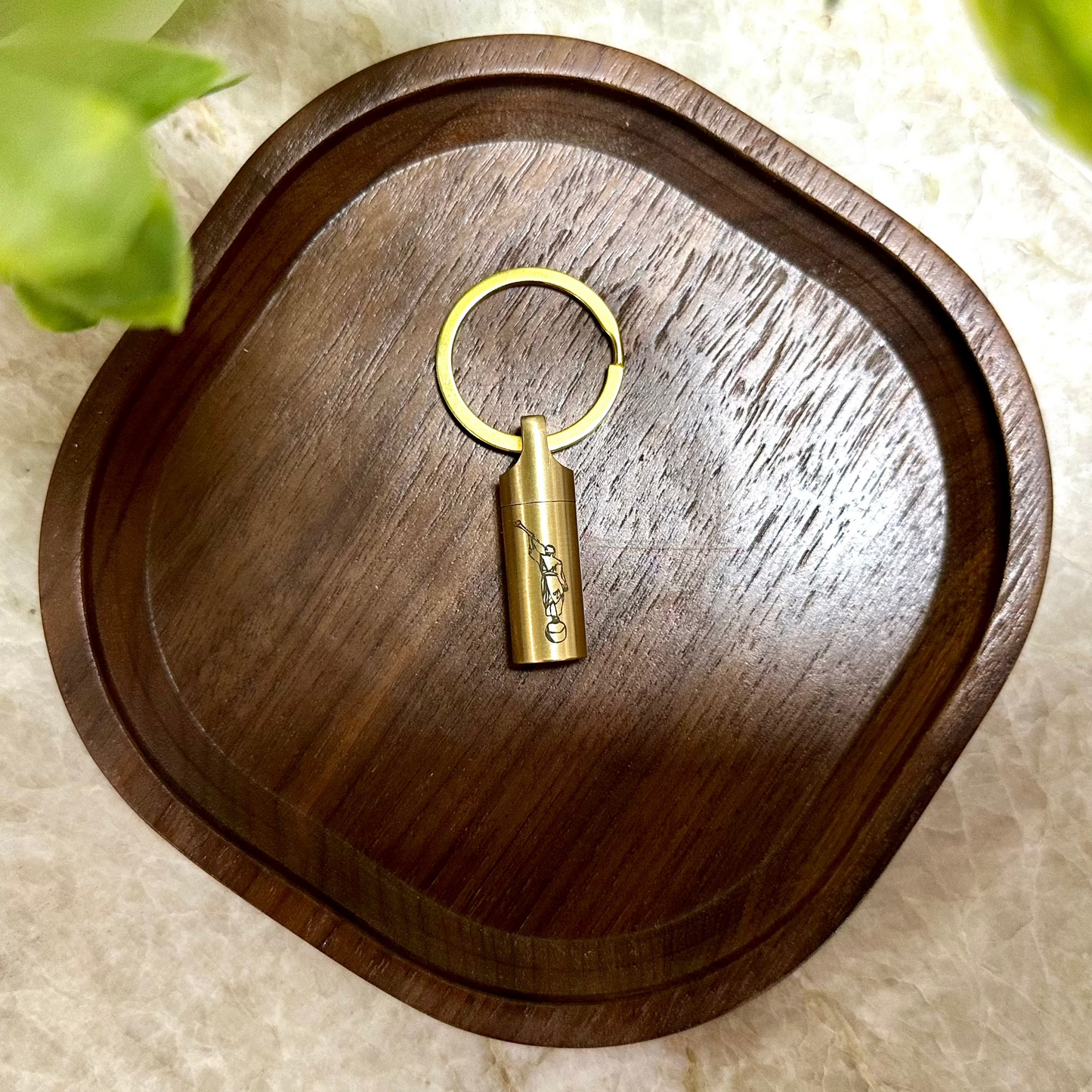 Consecrated oil vial made of Brass laying on a tray with a secure screw cap, featuring an elegant engraved design, ideal for Latter-day Saint priesthood blessings.
