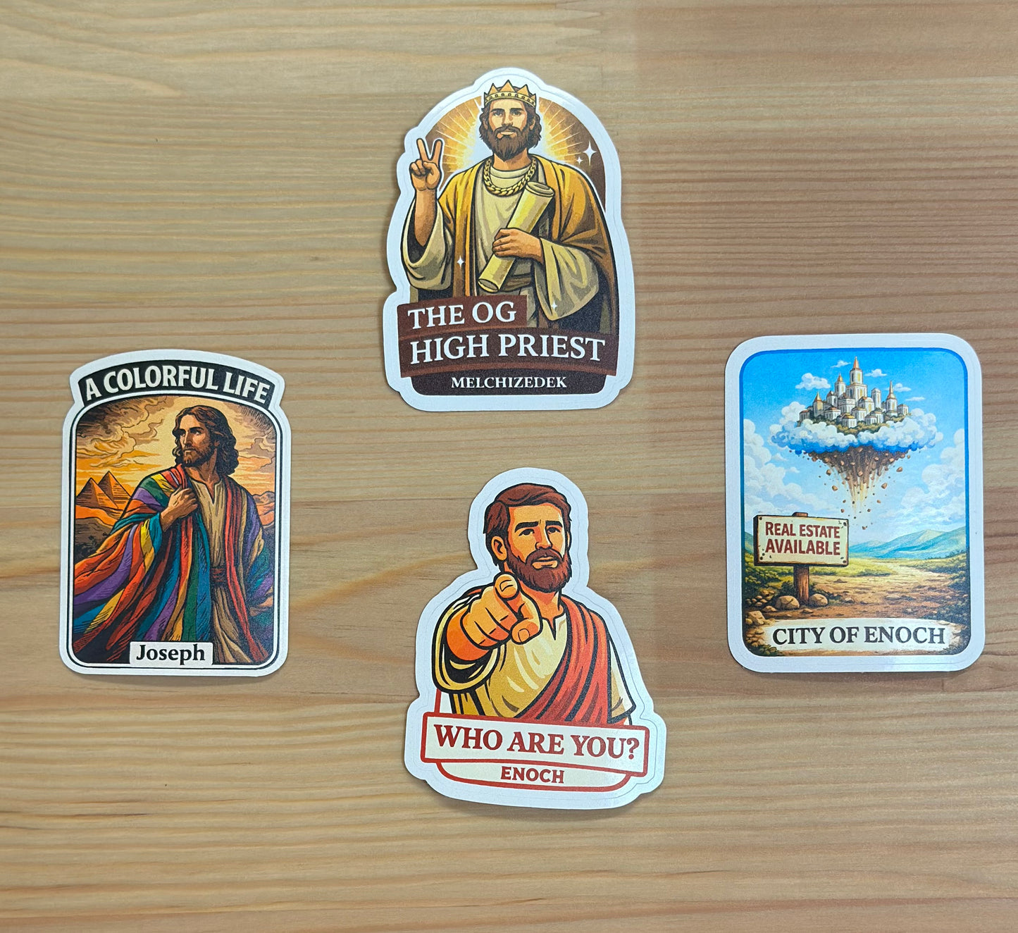 Four stickers featuring religious figures and a cityscape on a wooden surface
