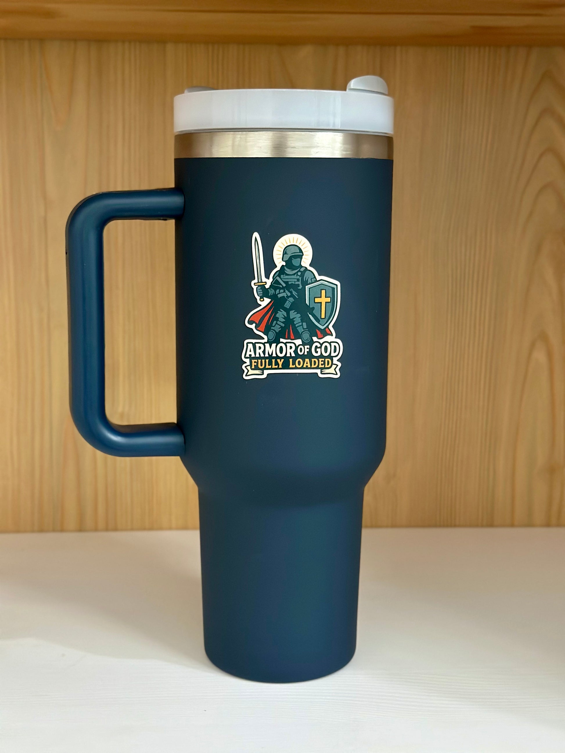 Blue travel mug with a design and text on a wooden surface