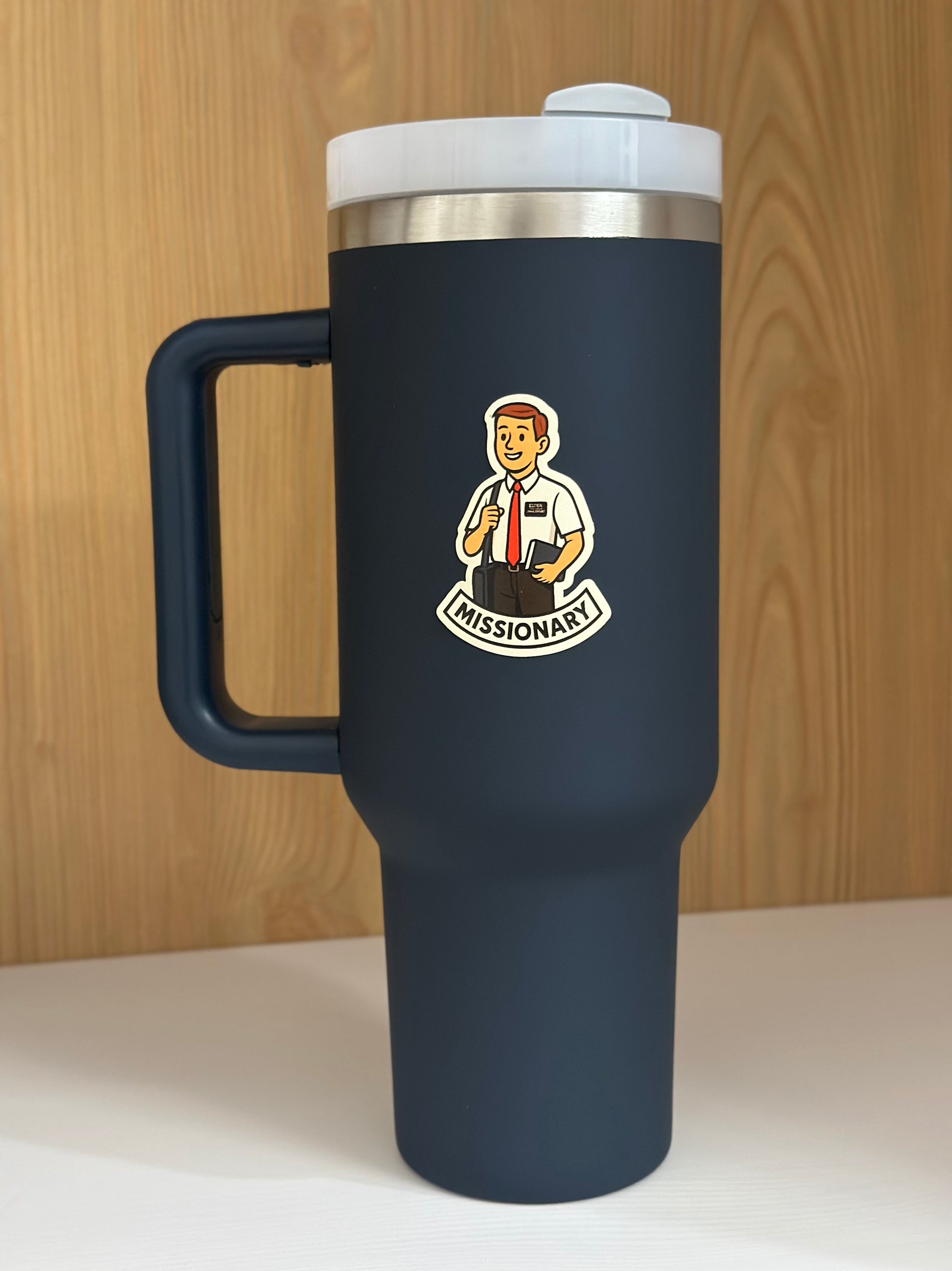 Navy blue travel mug with a white lid and 'Missionary' logo, LDS missionary sticker featuring a mormon missionary.